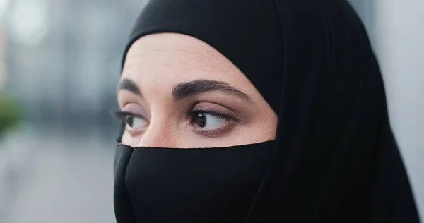 Ritratto ritagliato vista della seria donna d'affari indossa sciarpa testa e maschera protettiva in piedi per strada al momento della pausa e guardando la fotocamera. Concetto di pandemia di coronavirus — Foto Stock