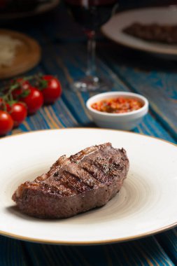 Izgara biftek, kiraz domatesleri ahşap masada tuz ve biber..