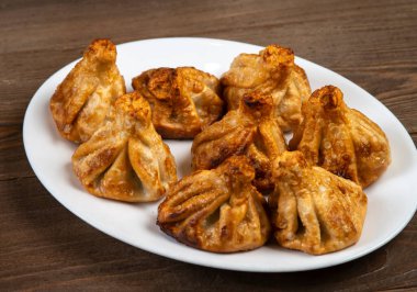 Beyaz bir tabakta kızarmış khinkali. Gürcü mutfağı..