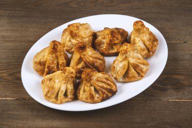 Beyaz bir tabakta kızarmış khinkali. Gürcü mutfağı..