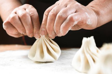 Aşçı ahşap masada khinkali yapıyor. İşlem hazırlığı Gürcistan yemeği. yiyecek konsepti.