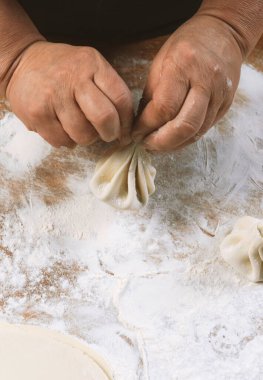Aşçı ahşap masada khinkali yapıyor. İşlem hazırlığı Gürcistan yemeği. yiyecek konsepti.