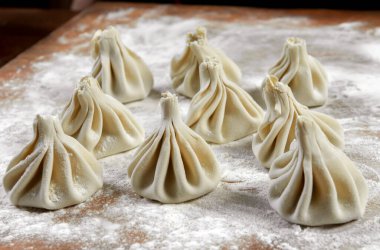 Aşçı ahşap masada khinkali yapıyor. İşlem hazırlığı Gürcistan yemeği. yiyecek konsepti.