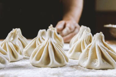 Aşçı ahşap masada khinkali yapıyor. İşlem hazırlığı Gürcistan yemeği. yiyecek konsepti.