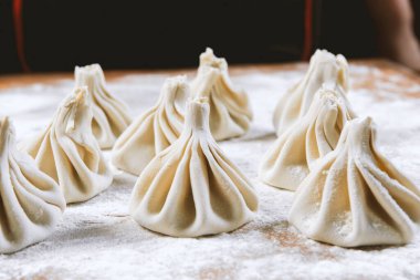 Aşçı ahşap masada khinkali yapıyor. İşlem hazırlığı Gürcistan yemeği. yiyecek konsepti.