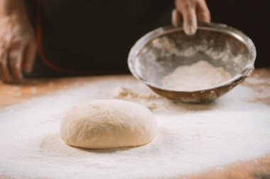 Hamur yoğurma fırını. Aşçı ahşap masada turta pişirmek için hamur yapıyor. İşlem hazırlığı ev yapımı hamur işi. Makarna, ekmek, spagetti, khachapuri, yemek konsepti.