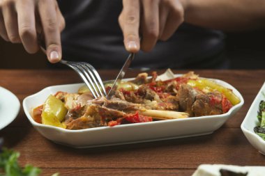 Solak adam kemik üzerinde sebzeli kuzu güveç yer. Khashlama, sebzeli sığır etinden hazırlanan popüler bir Ermeni yemeğidir. Khashlama tabakta. Kafkas yemekleri.