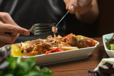 Solak adam kemik üzerinde sebzeli kuzu güveç yer. Khashlama, sebzeli sığır etinden hazırlanan popüler bir Ermeni yemeğidir. Khashlama tabakta. Kafkas yemekleri.