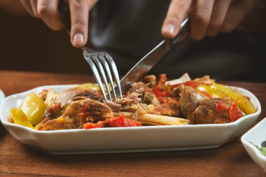 Solak adam kemik üzerinde sebzeli kuzu güveç yer. Khashlama, sebzeli sığır etinden hazırlanan popüler bir Ermeni yemeğidir. Khashlama tabakta. Kafkas yemekleri.