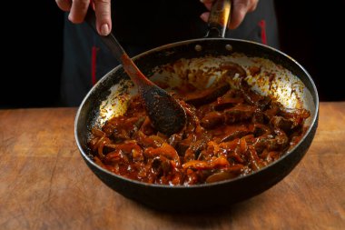 Aşçı eti sebzeli ve soğanlı bir kasede hazırlar. Doğu mutfağı.