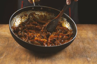 Aşçı eti sebzeli ve soğanlı bir kasede hazırlar. Doğu mutfağı.