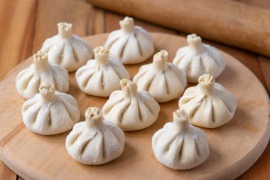 Ahşap masada çiğ donmuş khinkali. İşlem hazırlığı Gürcistan yemeği. yiyecek konsepti.