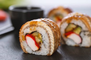 Pilavlı suşi, yengeç, salatalık, avokado, tobiko, yılan balığı. Suşi menüsü. Japon yemeği..