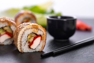 Pilavlı suşi, yengeç, salatalık, avokado, tobiko, yılan balığı. Suşi menüsü. Japon yemeği..
