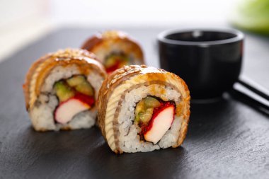 Pilavlı suşi, yengeç, salatalık, avokado, tobiko, yılan balığı. Suşi menüsü. Japon yemeği..