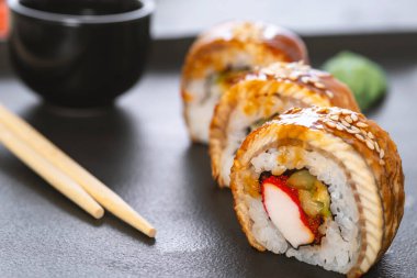 Pilavlı suşi, yengeç, salatalık, avokado, tobiko, yılan balığı. Suşi menüsü. Japon yemeği..
