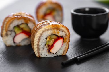 Pilavlı suşi, yengeç, salatalık, avokado, tobiko, yılan balığı. Suşi menüsü. Japon yemeği..
