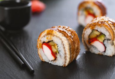 Pilavlı suşi, yengeç, salatalık, avokado, tobiko, yılan balığı. Suşi menüsü. Japon yemeği..