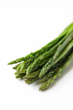 Beyaz arka planda bir demet taze kuşkonmaz.