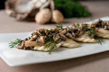 Mantarlı mantar porsiyonu ve beyaz tabakta otlar. .