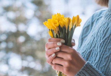 Bir buket sarı çiçeği tutan kadın