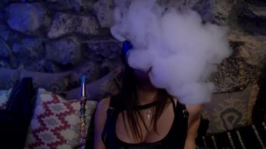 Gece kulübünde nargile içen seksi maskeli kız.
