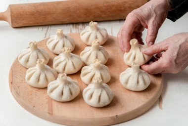 Pişirilmiş khinkali, hamur köftesi, elle pişirilmiş et. Hamurda sulu et ve ellerinde baharatlı otlar. Lezzetli sıcak Gürcü, Doğu, Buryat yemeği.
