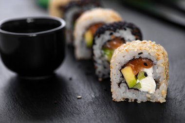 Pilavlı suşi, salatalık, avokado, somon, susam. Suşi menüsü. Japon yemeği..