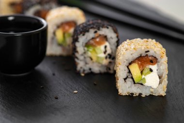 Pilavlı suşi, salatalık, avokado, somon, susam. Suşi menüsü. Japon yemeği..