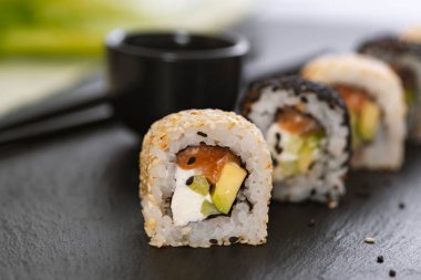 Pilavlı suşi, salatalık, avokado, somon, susam. Suşi menüsü. Japon yemeği..