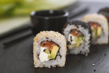 Pilavlı suşi, salatalık, avokado, somon, susam. Suşi menüsü. Japon yemeği..