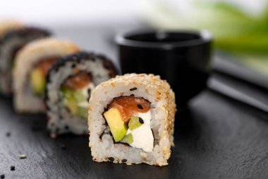 Pilavlı suşi, salatalık, avokado, somon, susam. Suşi menüsü. Japon yemeği..