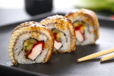 Pilavlı suşi, yengeç, salatalık, avokado, tobiko, yılan balığı. Suşi menüsü. Japon yemeği..