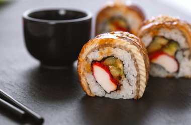 Pilavlı suşi, yengeç, salatalık, avokado, tobiko, yılan balığı. Suşi menüsü. Japon yemeği..