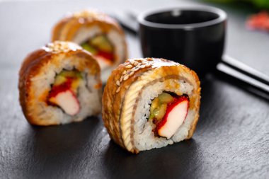 Pilavlı suşi, yengeç, salatalık, avokado, tobiko, yılan balığı. Suşi menüsü. Japon yemeği..