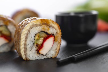 Pilavlı suşi, yengeç, salatalık, avokado, tobiko, yılan balığı. Suşi menüsü. Japon yemeği..