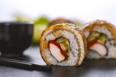 Pilavlı suşi, yengeç, salatalık, avokado, tobiko, yılan balığı. Suşi menüsü. Japon yemeği..