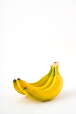 Beyaz arkaplanda benekleri olan bir grup muz meyvesi