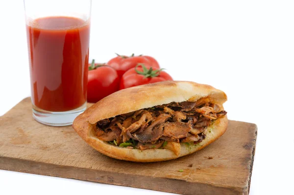 shawarma in pita bread ,tomatoes and tomato juice on a white background.doner kebab