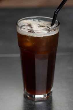Büyük bardakta buzlu kahve. Karanlık bir arka planda fotokopi alanı olan soğuk yaz içeceği