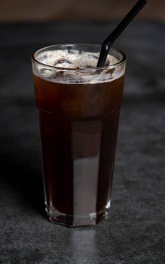 Büyük bardakta buzlu kahve. Karanlık bir arka planda fotokopi alanı olan soğuk yaz içeceği