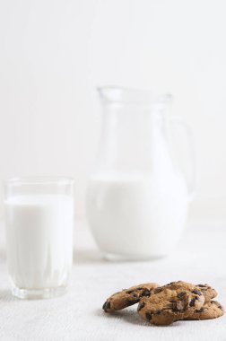 Süt ve çikolata parçalı kurabiyeler beyaz ahşap arka plan fotokopi alanı üzerinde.