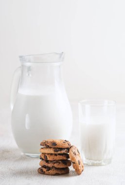Süt ve çikolata parçalı kurabiyeler beyaz ahşap arka plan fotokopi alanı üzerinde.