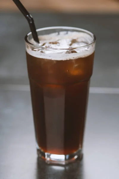 tall glass cold brew coffee with ice on black or dark background