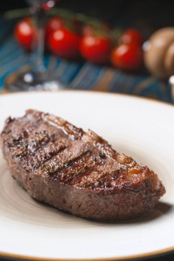 Izgara biftek, kiraz domatesleri ahşap masada tuz ve biber..