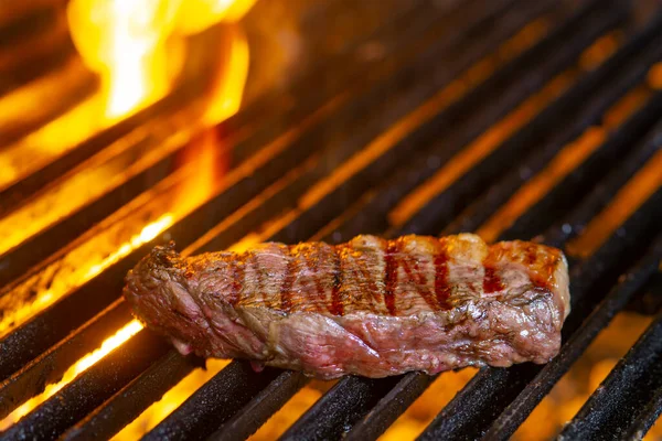 Izgarada alevler içinde biftek cızırdıyor.