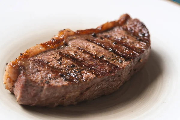 Gegrilde Biefstuk Met Specerijen Witte Plaat Blauwe Houten Ondergrond — Stockfoto