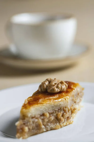 Geleneksel Arap tatlı baklavası ve bir fincan kahve ya da çayla birlikte beyaz tabakta ceviz. Ev yapımı fındıklı ve ballı baklava..