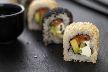Pilavlı suşi, salatalık, avokado, somon, susam. Suşi menüsü. Japon yemeği..