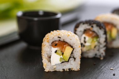 Pilavlı suşi, salatalık, avokado, somon, susam. Suşi menüsü. Japon yemeği..